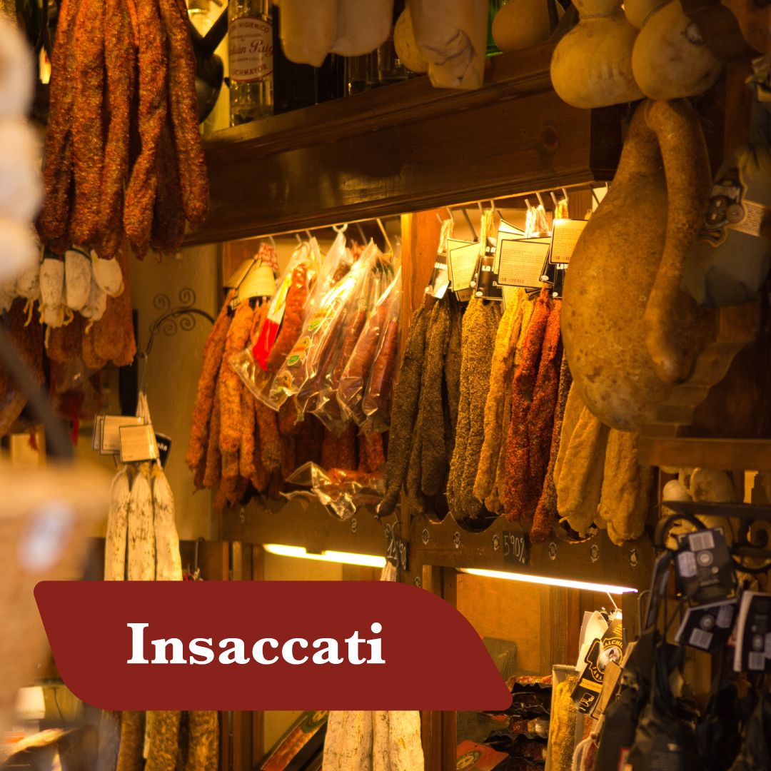 Insaccati calabresi appesi a stagionare in una bottega: salsicce, soppressate e salami