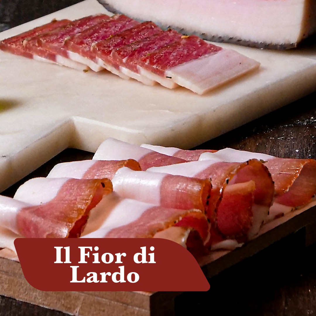 Fior di lardo di Suino Nero affettato sottile su tagliere di marmo con pancetta e salumi