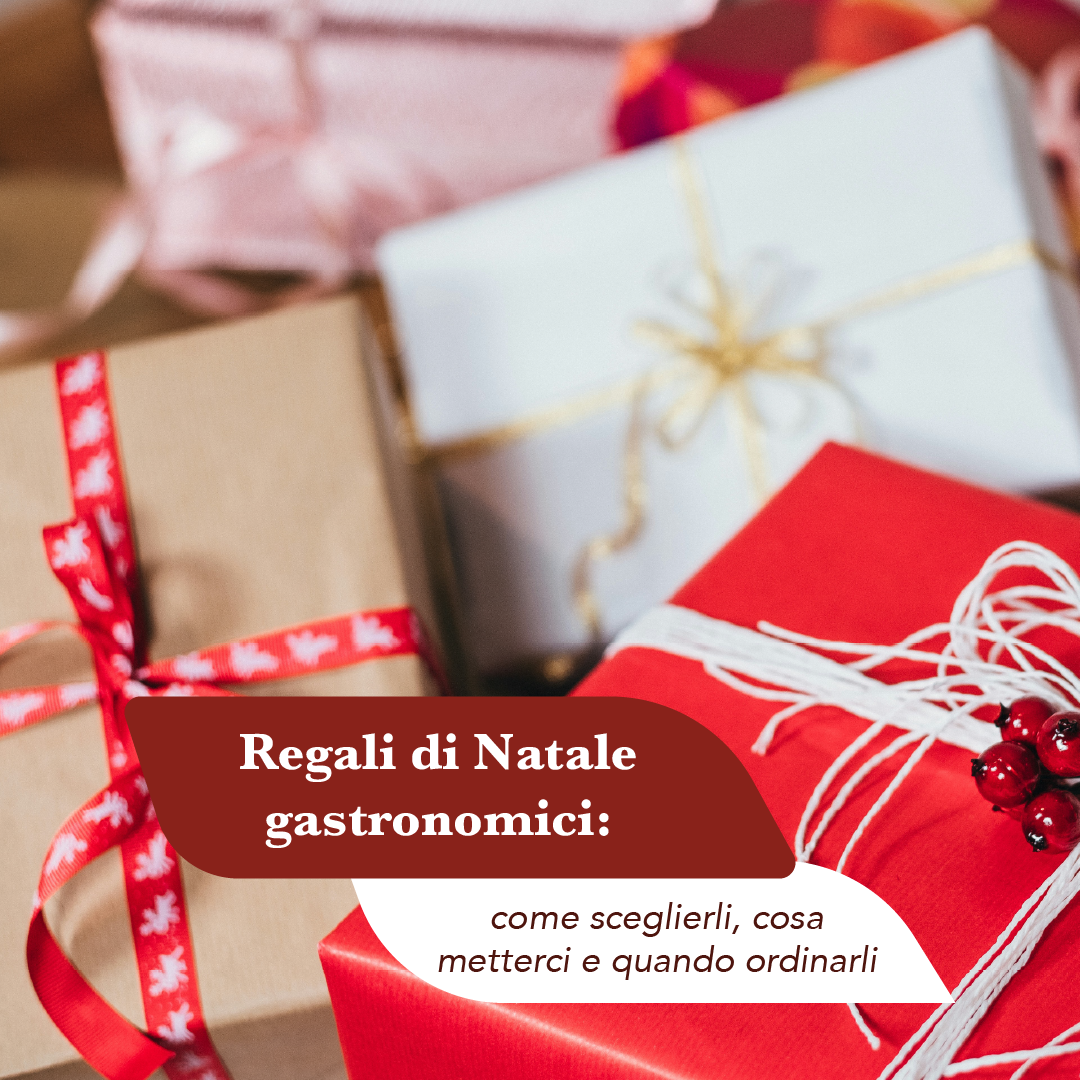 Pacchi regalo di Natale incartati in carta rossa, avana e bianca con nastri e bacche rosse