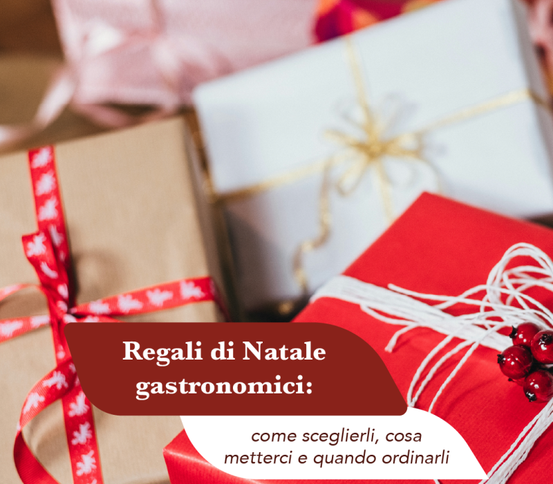 Pacchi regalo di Natale incartati in carta rossa, avana e bianca con nastri e bacche rosse